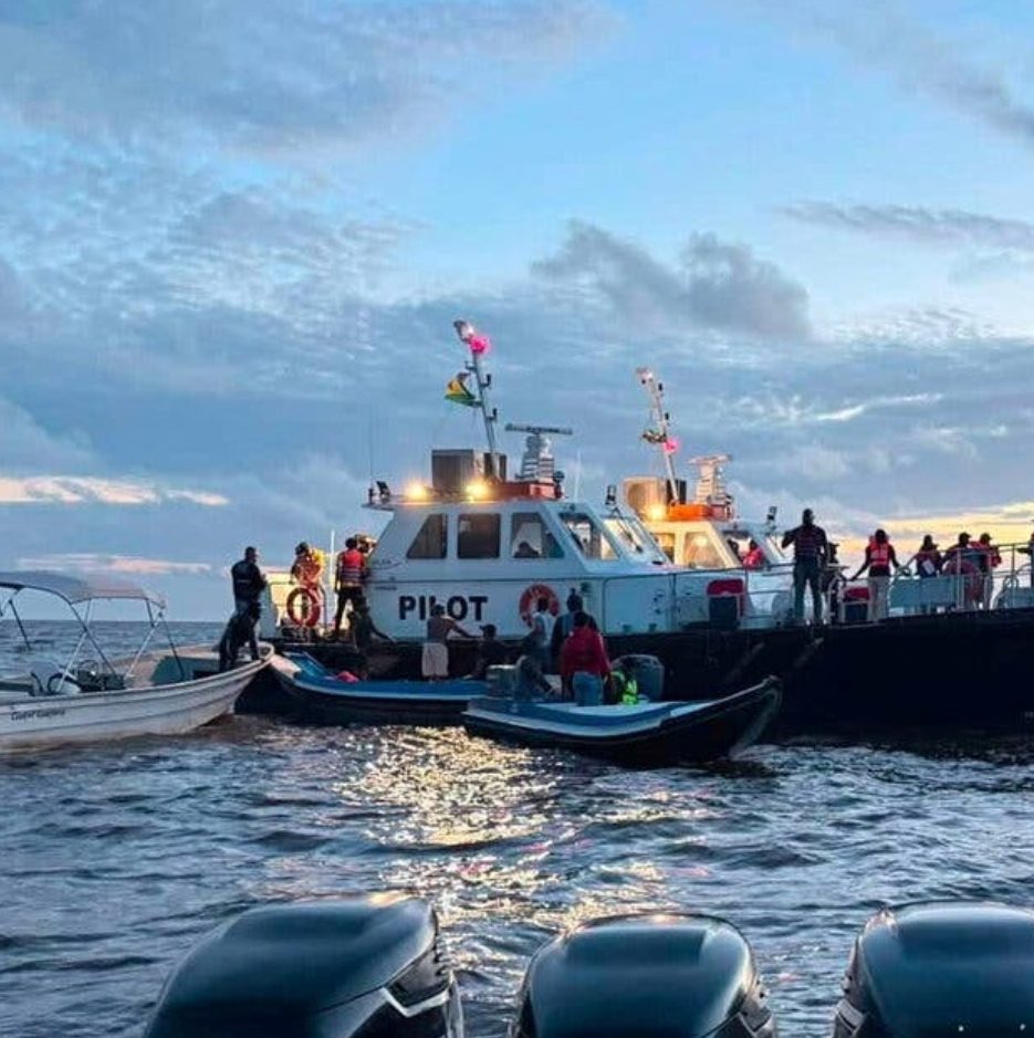 Rescue boats alongside a pilot vessel at dusk during the search operation